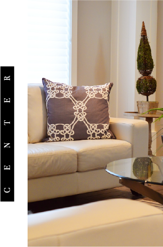 sala con moviliario color blanco y un cojin color morado y blanco